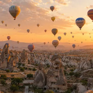 Hot air balloons rising over Cappadocia at sunrise