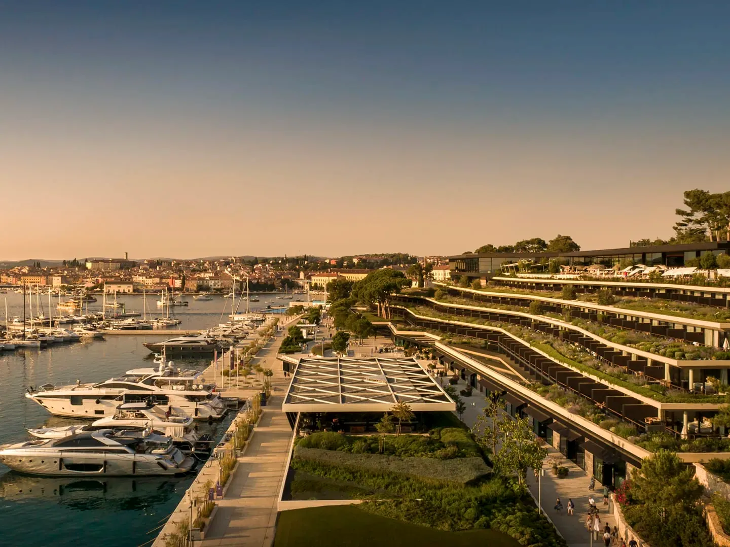Aerial of Grand Park Hotel Rovinj cascading down to the marina, with Rovinj old town in the distance