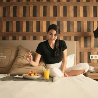 Breakfast tray on a hotel bed at sunrise