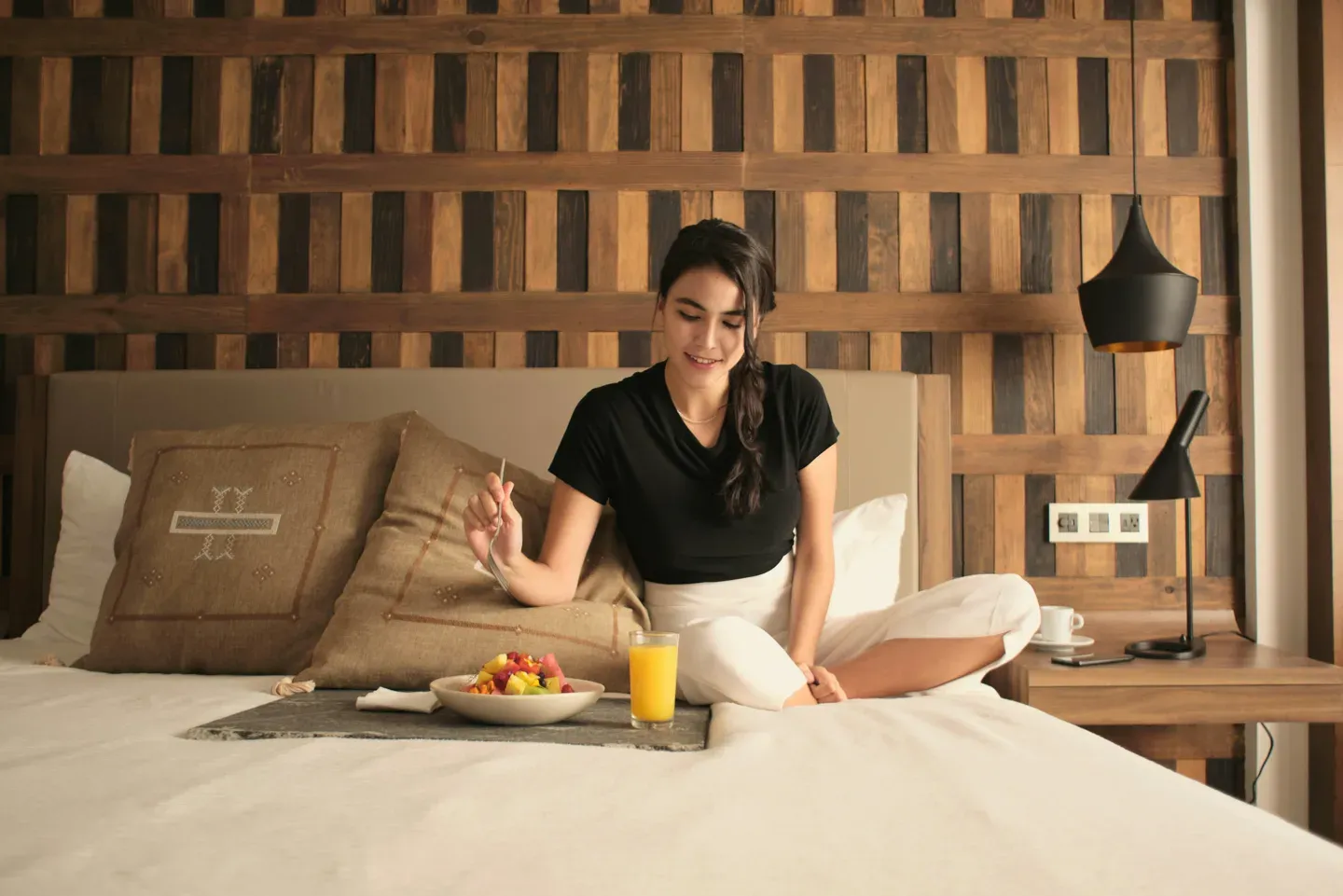 Breakfast tray on a hotel bed at sunrise