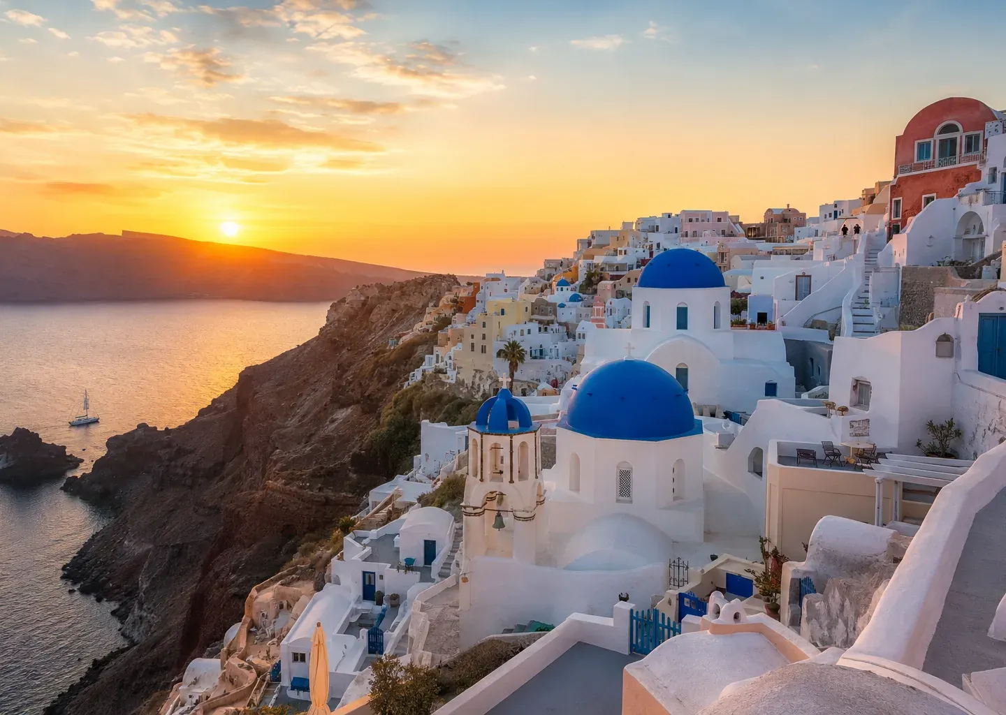 Santorini blue-domed church above the caldera at sunset