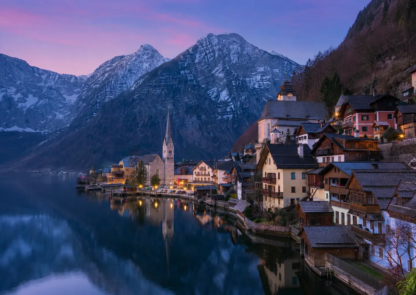 Alpine village and church mirrored in a still mountain lake