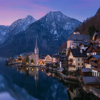 Alpine village and church mirrored in a still mountain lake