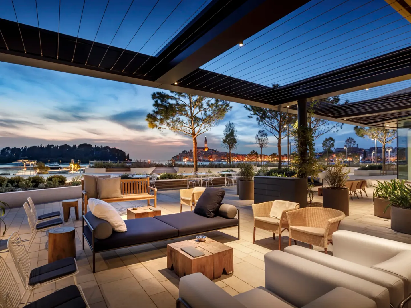 Outdoor terrace at Grand Park Hotel Rovinj at dusk overlooking the marina