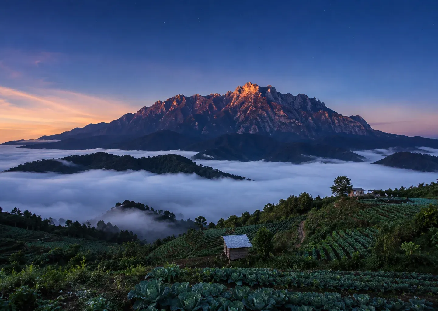 Sunrise over misty farmland and mountains in Sabah