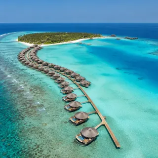 Aerial of a curving chain of Maldives overwater villas