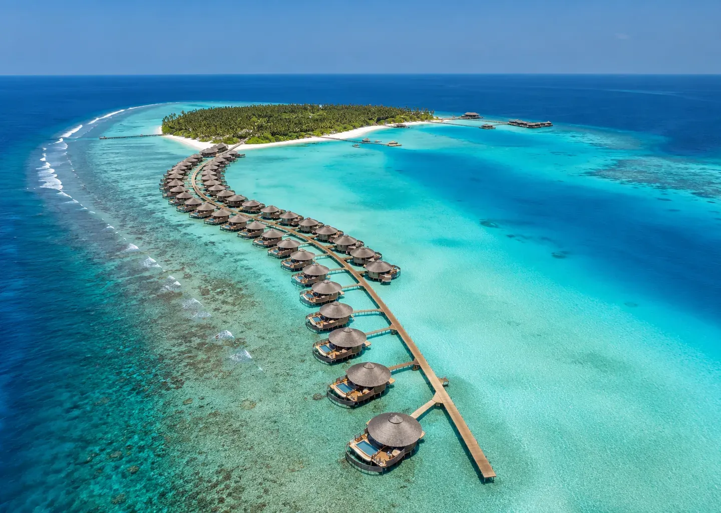 Aerial of a curving chain of Maldives overwater villas