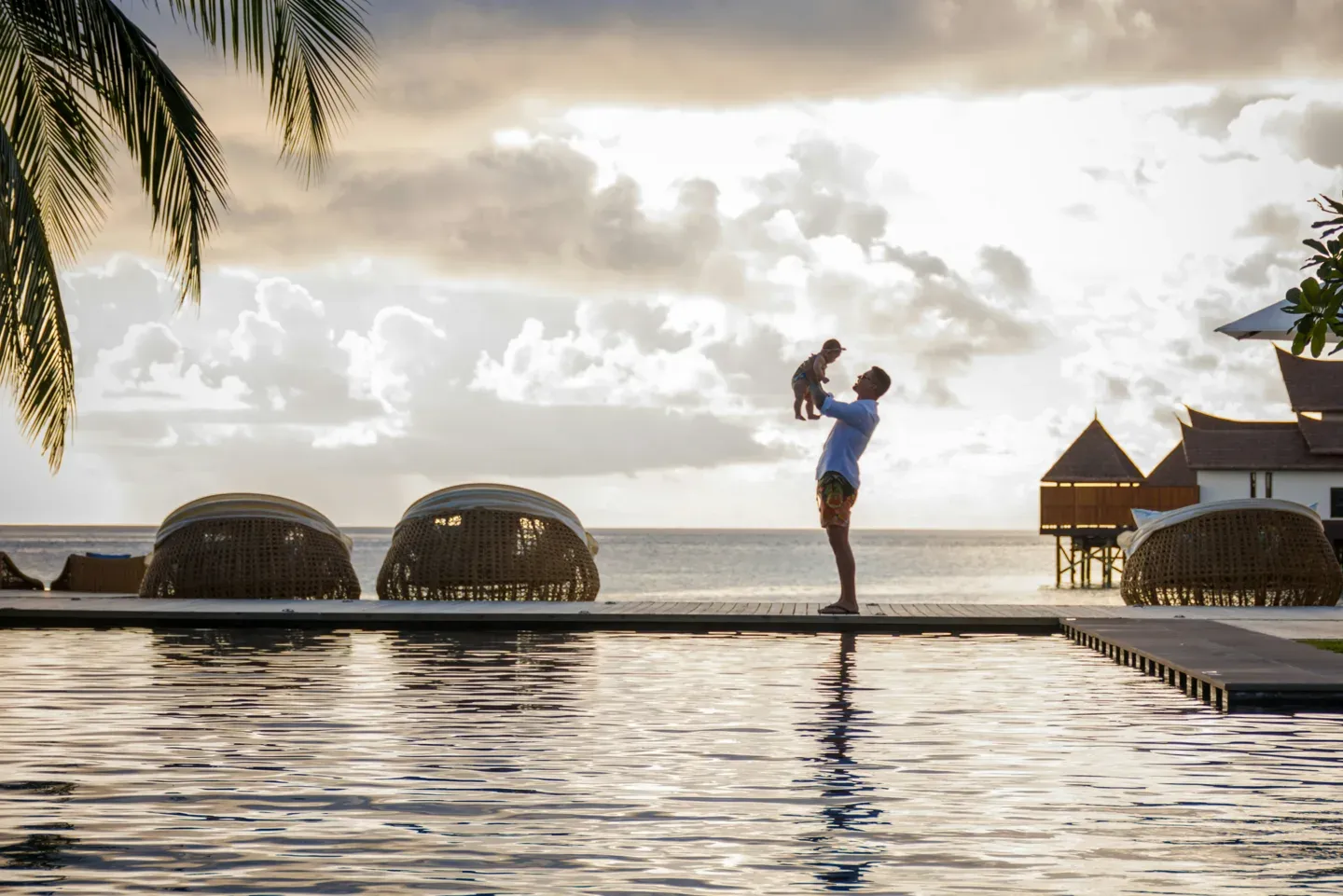 Sunset infinity pool with a parent and child