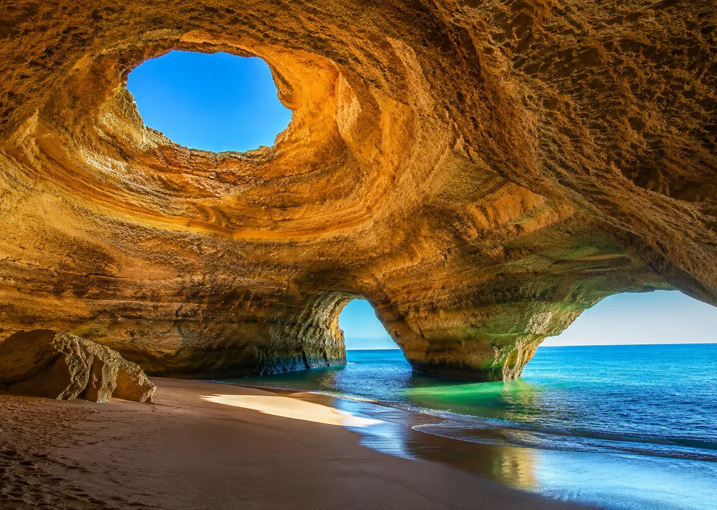 Sea-carved stone arch over a turquoise cove