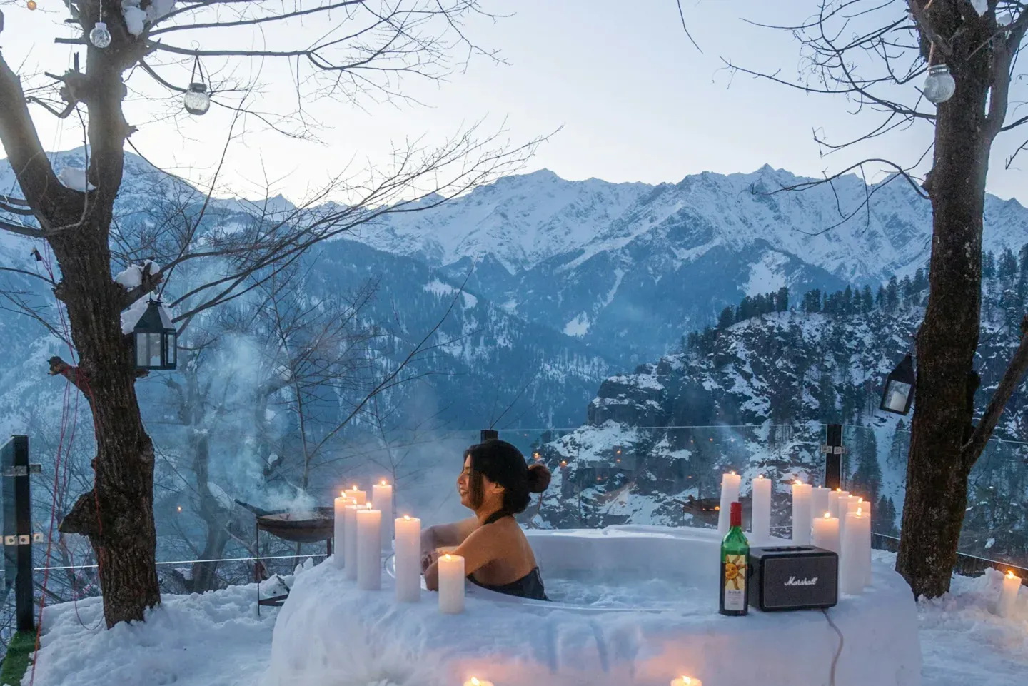 Outdoor hot tub in snow with portable speaker