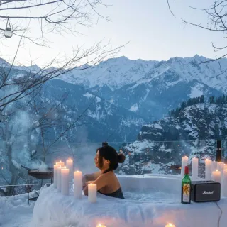 Outdoor hot tub in snow with portable speaker