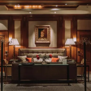 Wood-panelled library lounge with a framed portrait